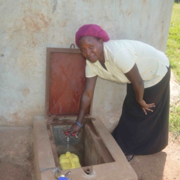 Teacher AgnesTeacher Agnes freut sich über Wasser in der Nabagereka Schule.